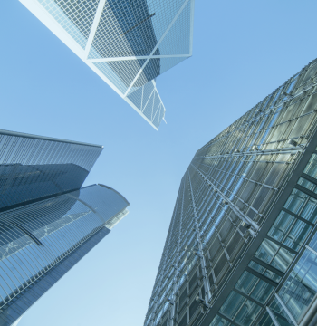 looking up at 3 glass buildings